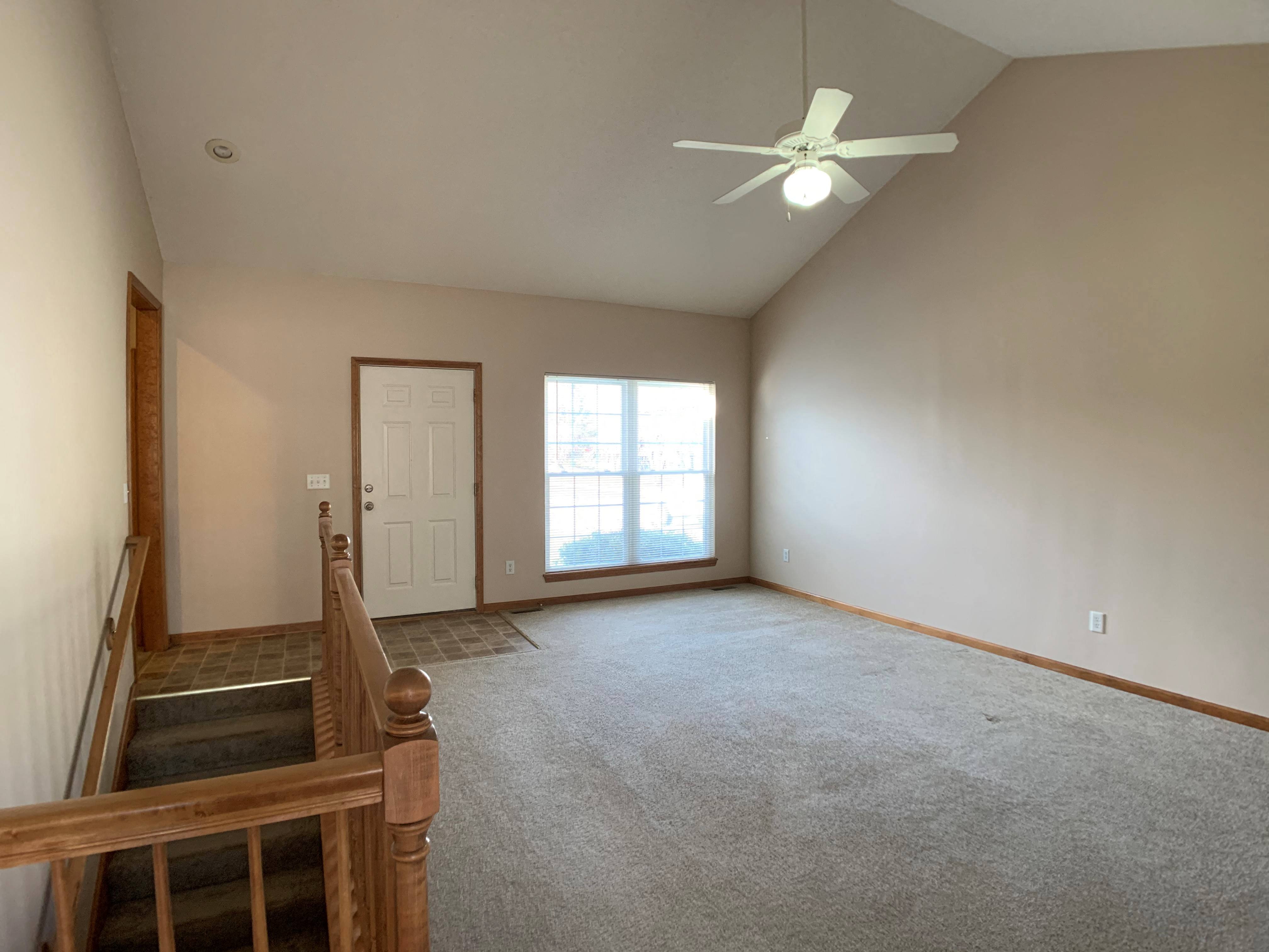 Living room with large window and ceiling fan